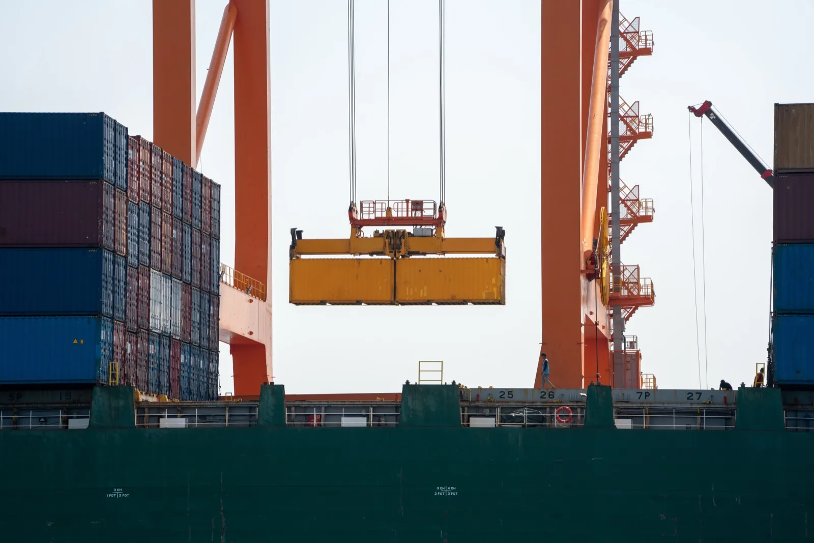 Crane loading a cargo container from a truck at a container terminal